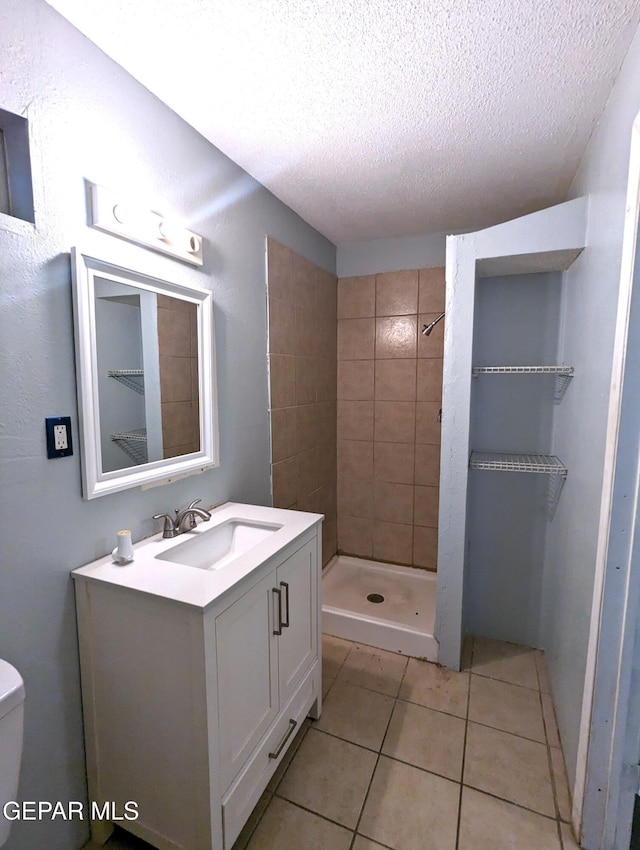 3308 Tularosa Ave, El Paso, TX 79903 - bathroom featuring a textured ceiling, a stall shower, tile patterned flooring, and vanity