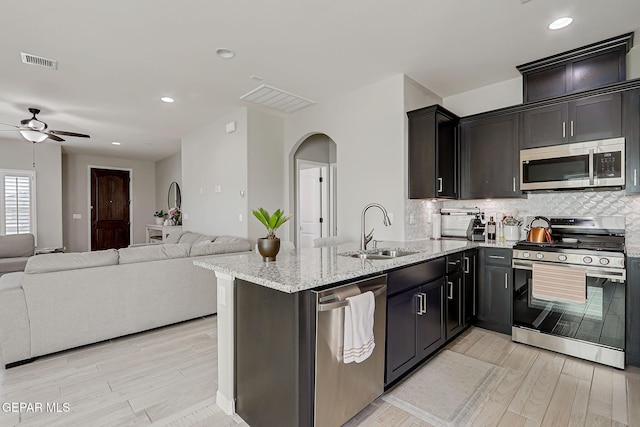 12820 Monmouth Ave, El Paso, TX 79928 - kitchen with stainless steel appliances, arched walkways, light wood-style flooring, a ceiling fan, and recessed lighting