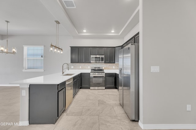 14772 John Mcneely Ave, El Paso, TX 79938 - kitchen featuring stainless steel appliances, backsplash, a peninsula, a chandelier, and light countertops