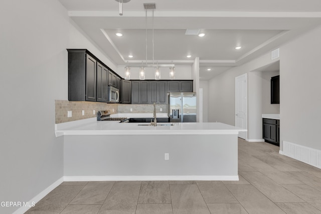 14772 John Mcneely Ave, El Paso, TX 79938 - kitchen with appliances with stainless steel finishes, light countertops, a peninsula, decorative backsplash, and light tile patterned floors