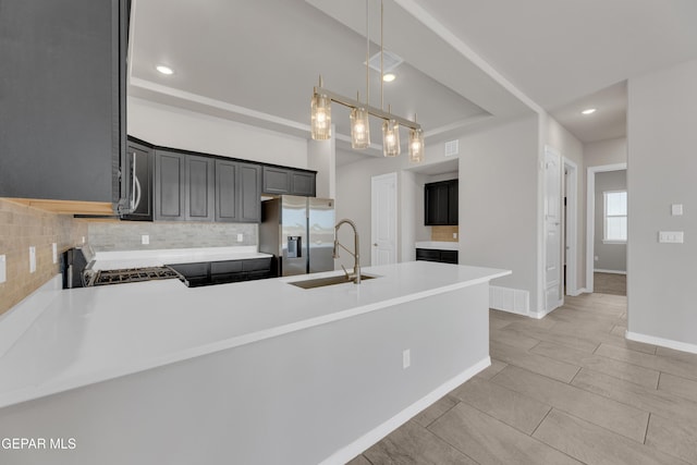 14772 John Mcneely Ave, El Paso, TX 79938 - kitchen with appliances with stainless steel finishes, backsplash, light countertops, a peninsula, and recessed lighting