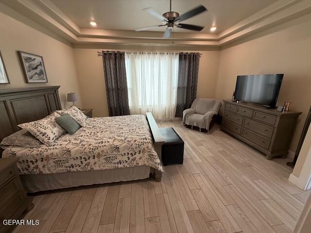 2313 Dancing Piper Way, El Paso, TX 79911 - bedroom featuring a tray ceiling, light wood-type flooring, and a ceiling fan