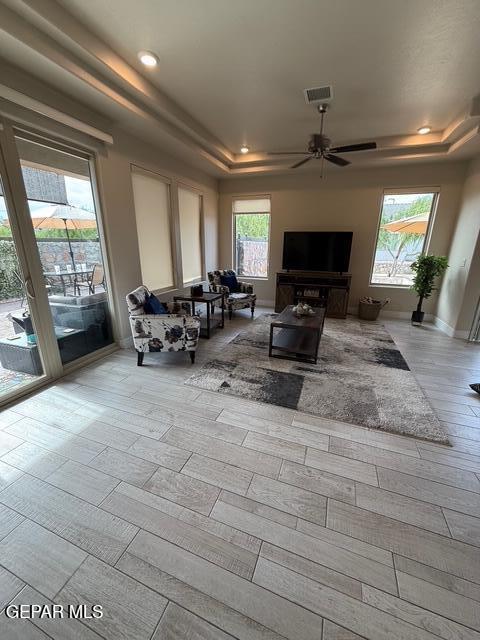 2313 Dancing Piper Way, El Paso, TX 79911 - living area with a tray ceiling, a ceiling fan, recessed lighting, and wood finished floors