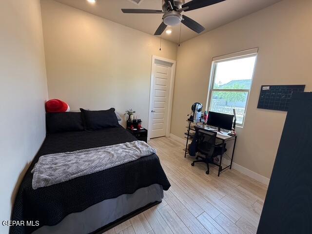 2313 Dancing Piper Way, El Paso, TX 79911 - bedroom with light wood-style flooring, a desk, and ceiling fan