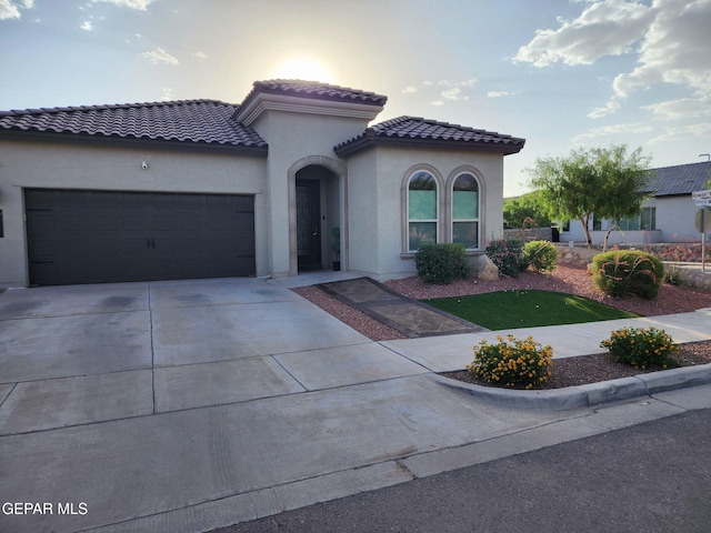 2313 Dancing Piper Way, El Paso, TX 79911 - mediterranean / spanish-style house featuring a garage, a tiled roof, stucco siding, and concrete driveway
