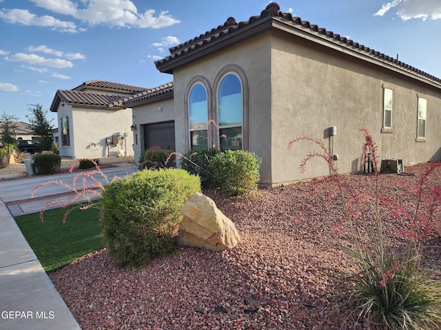 2313 Dancing Piper Way, El Paso, TX 79911 - view of property exterior with an attached garage, stucco siding, a tile roof, and concrete driveway