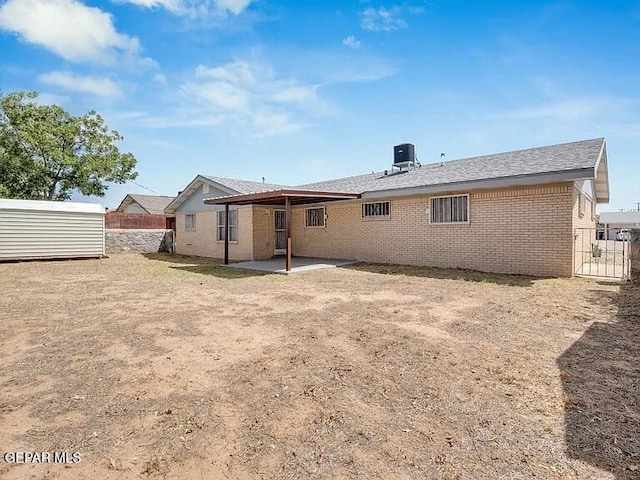 3305 Killarney St, El Paso, TX 79925 - back of house with brick siding, a patio area, and a storage unit