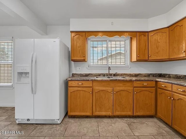 3305 Killarney St, El Paso, TX 79925 - kitchen featuring white fridge with ice dispenser, dark countertops, and brown cabinets