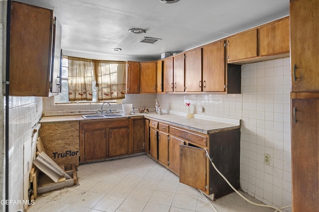 4008 Tularosa Ave, El Paso, TX 79903 - kitchen with brown cabinetry, light tile patterned flooring, backsplash, and tile countertops