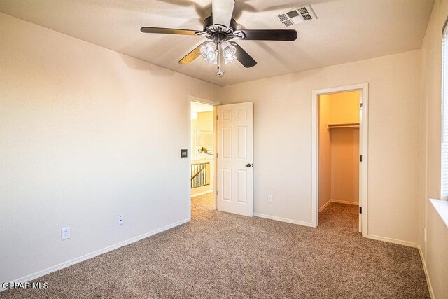 5004 Gold Ranch Ave, El Paso, TX 79934 - unfurnished bedroom featuring carpet floors, a spacious closet, a ceiling fan, and a closet