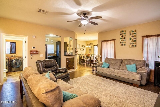 5004 Gold Ranch Ave, El Paso, TX 79934 - living area featuring washer and dryer, ceiling fan, dark wood finished floors, arched walkways, and healthy amount of natural light
