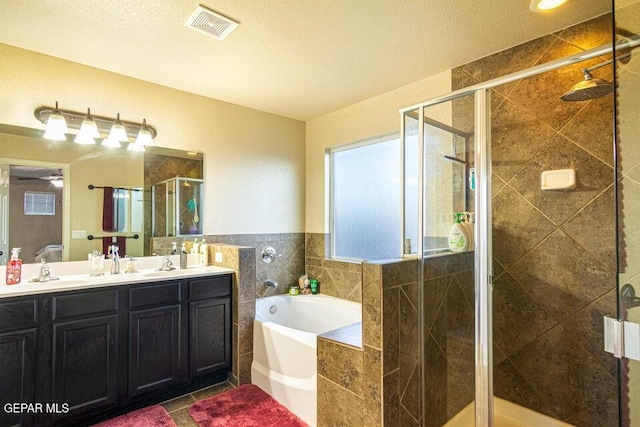 5004 Gold Ranch Ave, El Paso, TX 79934 - bathroom featuring a bath, a stall shower, double vanity, tile patterned floors, and a textured ceiling
