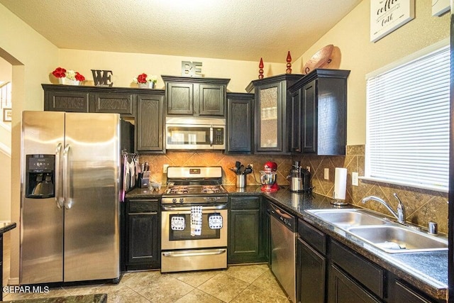 5004 Gold Ranch Ave, El Paso, TX 79934 - kitchen with appliances with stainless steel finishes, decorative backsplash, dark countertops, a textured ceiling, and light tile patterned floors