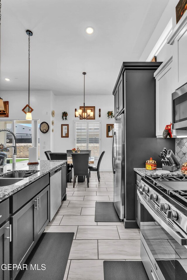 12328 Desert Heights Ct, El Paso, TX 79938 - kitchen featuring appliances with stainless steel finishes, a chandelier, light stone counters, recessed lighting, and hanging light fixtures