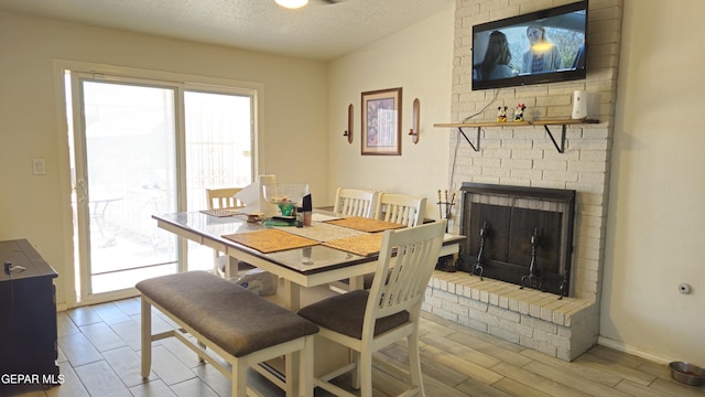 5028 Sagittarius Ave, El Paso, TX 79924 - dining area featuring a textured ceiling, a fireplace, and wood finished floors