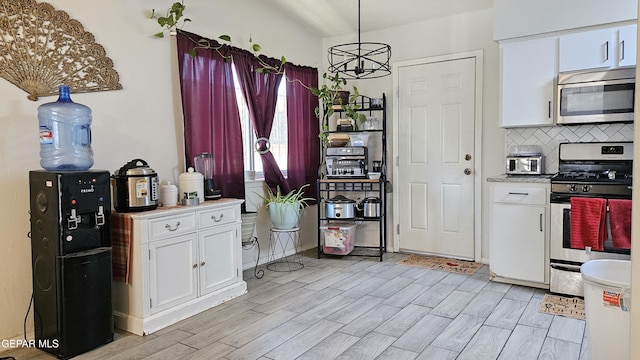5028 Sagittarius Ave, El Paso, TX 79924 - kitchen featuring stainless steel appliances, white cabinets, light wood finished floors, light countertops, and tasteful backsplash