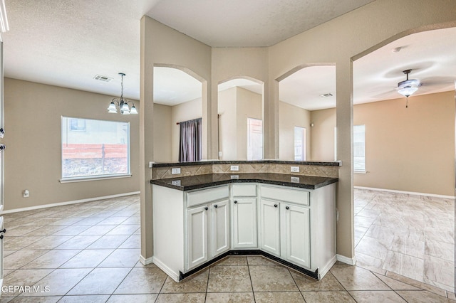 14376 N Cave Dr, El Paso, TX 79938 - kitchen featuring light tile patterned flooring, white cabinets, arched walkways, and a chandelier