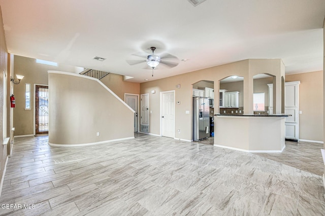 14376 N Cave Dr, El Paso, TX 79938 - unfurnished living room featuring ceiling fan, arched walkways, and stairway