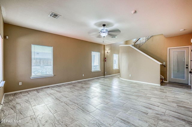 14376 N Cave Dr, El Paso, TX 79938 - unfurnished living room featuring healthy amount of natural light, ceiling fan, and stairway