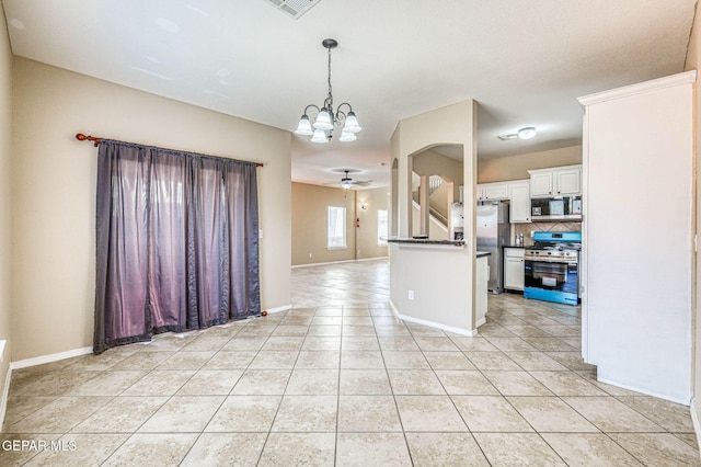 14376 N Cave Dr, El Paso, TX 79938 - kitchen featuring stainless steel appliances, light tile patterned floors, dark countertops, a chandelier, and white cabinetry