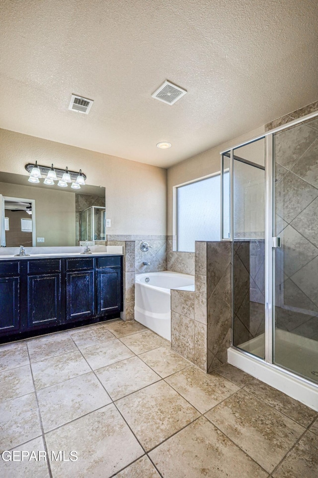 14376 N Cave Dr, El Paso, TX 79938 - full bath with a bath, double vanity, a shower stall, a textured ceiling, and tile patterned floors