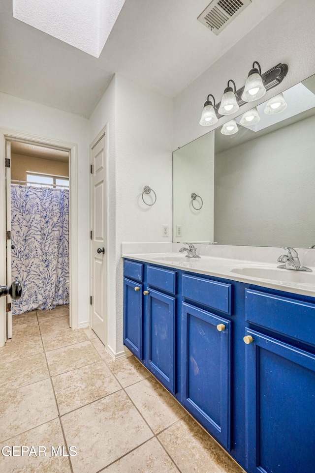 14376 N Cave Dr, El Paso, TX 79938 - full bathroom featuring tile patterned floors, double vanity, and a skylight