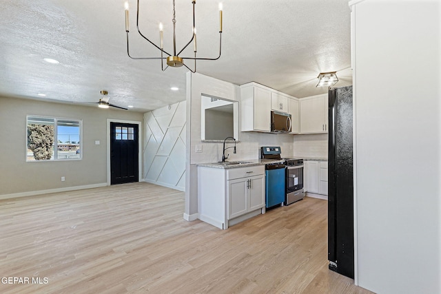 5112 Sun Valley Dr, El Paso, TX 79924 - kitchen featuring appliances with stainless steel finishes, a textured ceiling, light wood-style flooring, white cabinetry, and a chandelier