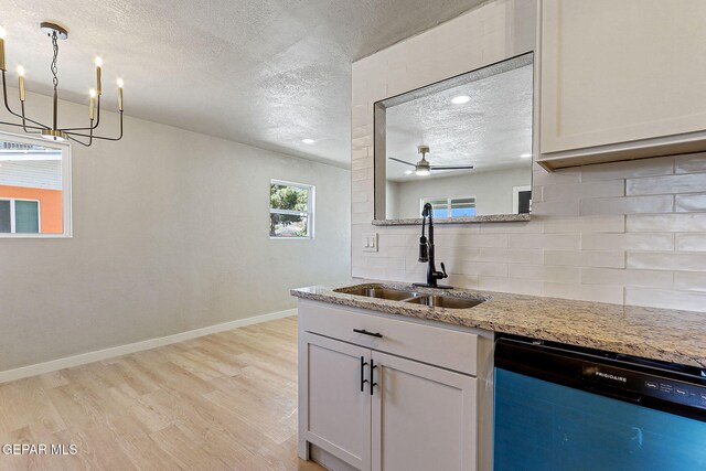 5112 Sun Valley Dr, El Paso, TX 79924 - kitchen with dishwasher, a textured ceiling, tasteful backsplash, light wood-type flooring, and a chandelier