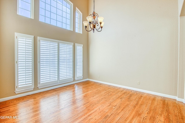 6570 Eagle Ridge Dr, El Paso, TX 79912 - unfurnished room featuring a chandelier, wood finished floors, and a towering ceiling