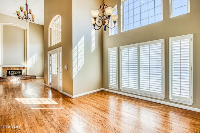 6570 Eagle Ridge Dr, El Paso, TX 79912 - entrance foyer featuring a chandelier, a towering ceiling, wood finished floors, and a fireplace