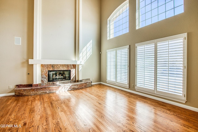 6570 Eagle Ridge Dr, El Paso, TX 79912 - unfurnished living room with wood finished floors, a fireplace, and a high ceiling