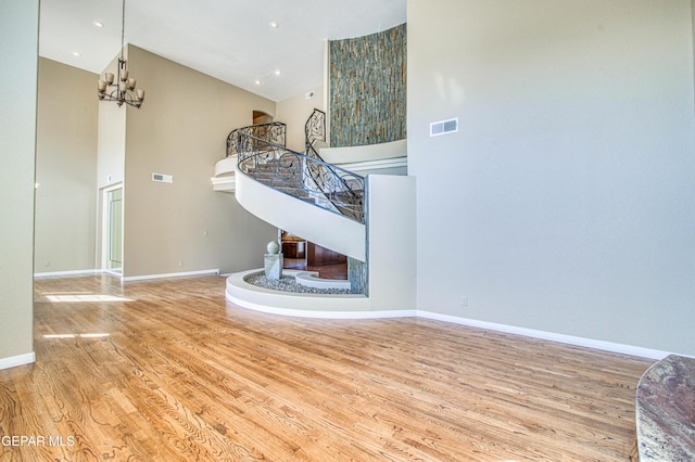 6570 Eagle Ridge Dr, El Paso, TX 79912 - unfurnished living room with high vaulted ceiling, wood finished floors, and a chandelier