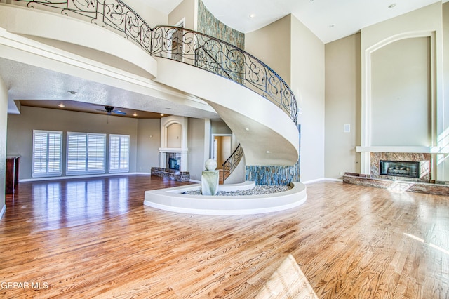 6570 Eagle Ridge Dr, El Paso, TX 79912 - stairs with a premium fireplace, wood finished floors, a towering ceiling, and ceiling fan