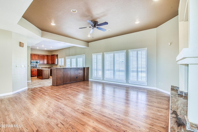 6570 Eagle Ridge Dr, El Paso, TX 79912 - unfurnished living room featuring light wood-type flooring, a ceiling fan, a textured ceiling, recessed lighting, and a fireplace