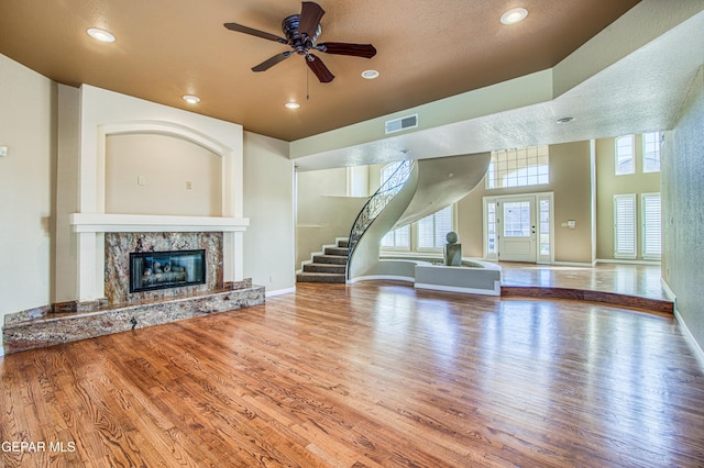 6570 Eagle Ridge Dr, El Paso, TX 79912 - unfurnished living room featuring a fireplace, wood finished floors, plenty of natural light, ceiling fan, and recessed lighting