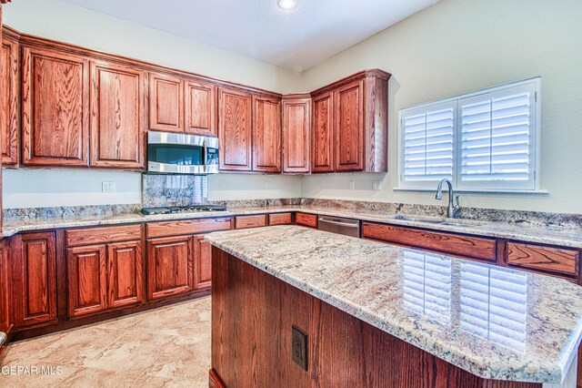 6570 Eagle Ridge Dr, El Paso, TX 79912 - kitchen featuring appliances with stainless steel finishes, light stone counters, a center island, recessed lighting, and brown cabinetry