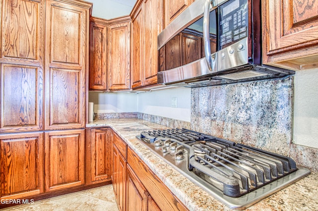 6570 Eagle Ridge Dr, El Paso, TX 79912 - kitchen featuring appliances with stainless steel finishes, brown cabinets, and light stone counters