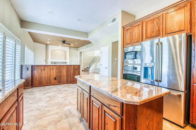 6570 Eagle Ridge Dr, El Paso, TX 79912 - kitchen with stainless steel appliances, brown cabinets, plenty of natural light, a kitchen island, and recessed lighting