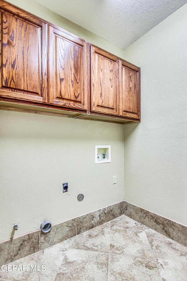6570 Eagle Ridge Dr, El Paso, TX 79912 - laundry room featuring cabinet space, hookup for a washing machine, electric dryer hookup, and a textured ceiling