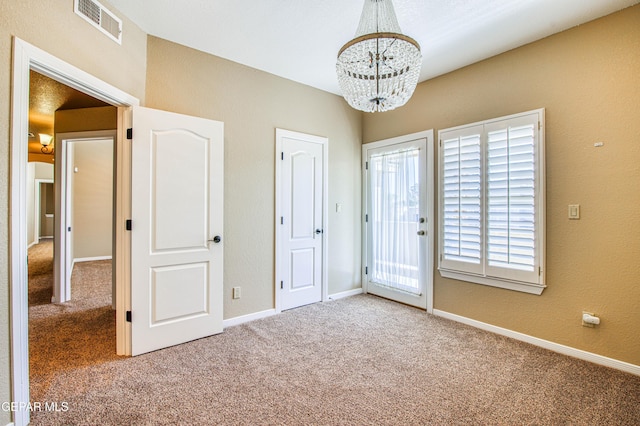 6570 Eagle Ridge Dr, El Paso, TX 79912 - unfurnished bedroom with a chandelier, carpet, and access to outside