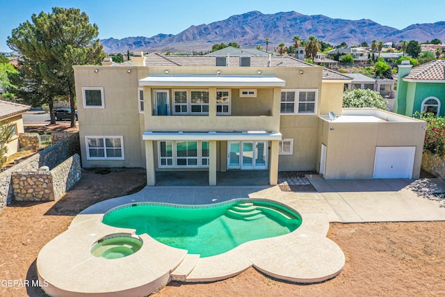 6570 Eagle Ridge Dr, El Paso, TX 79912 - rear view of property with a mountain view, stucco siding, a patio, and a pool with connected hot tub