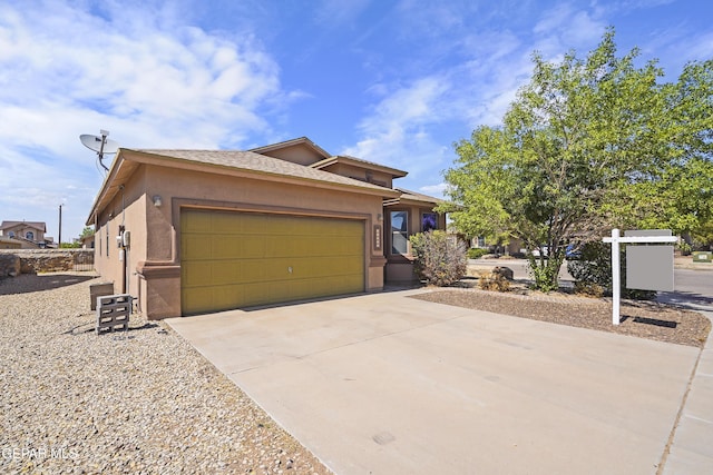 14477 Jacinto Ramos Ave, El Paso, TX 79938 - view of front of house with stucco siding, a garage, and driveway