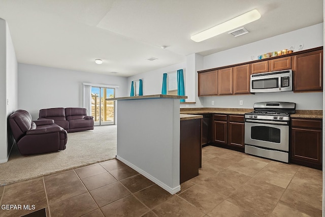 14477 Jacinto Ramos Ave, El Paso, TX 79938 - kitchen featuring stainless steel appliances, open floor plan, carpet flooring, and tile patterned floors
