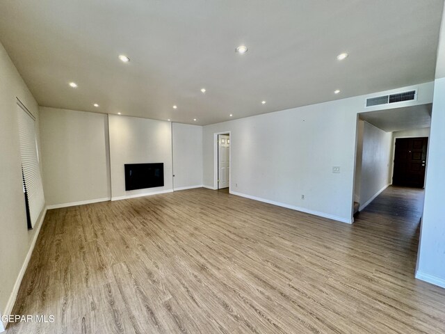 536 Satellite Dr, El Paso, TX 79912 - unfurnished living room with light wood finished floors, recessed lighting, and a fireplace