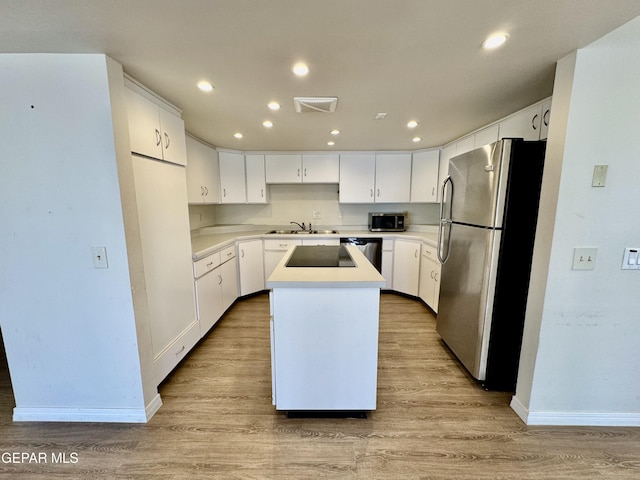 536 Satellite Dr, El Paso, TX 79912 - kitchen featuring appliances with stainless steel finishes, a center island, light wood-style flooring, recessed lighting, and white cabinets