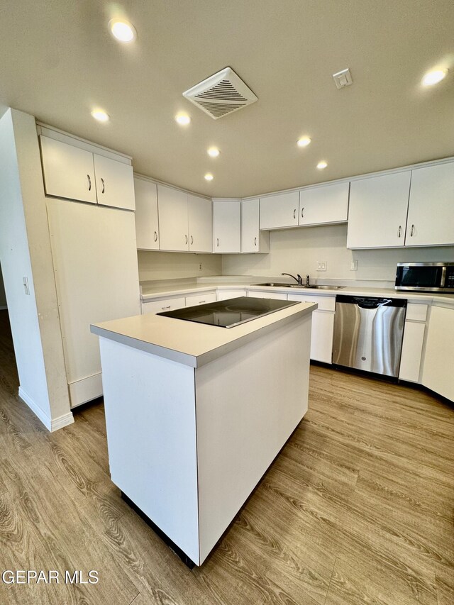 536 Satellite Dr, El Paso, TX 79912 - kitchen featuring appliances with stainless steel finishes, a center island, white cabinets, recessed lighting, and light wood-style floors