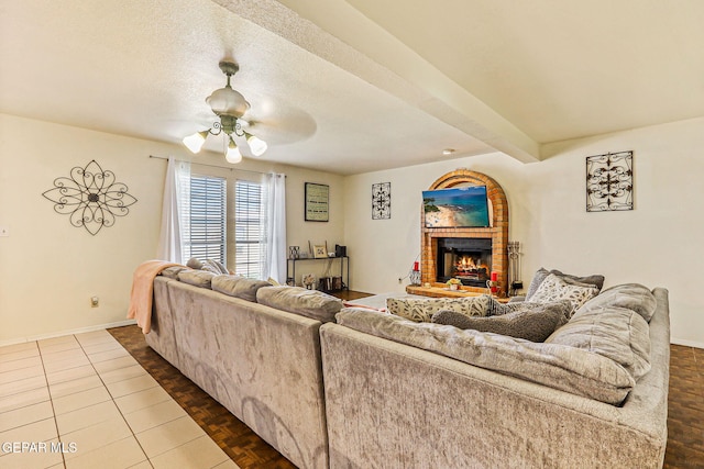 9769 Galilee Dr, El Paso, TX 79927 - living room with a fireplace, ceiling fan, dark tile patterned floors, and beamed ceiling