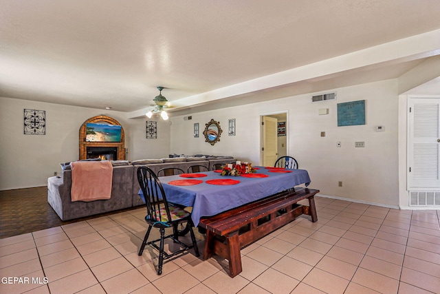 9769 Galilee Dr, El Paso, TX 79927 - dining area featuring light tile patterned flooring, a ceiling fan, and a warm lit fireplace
