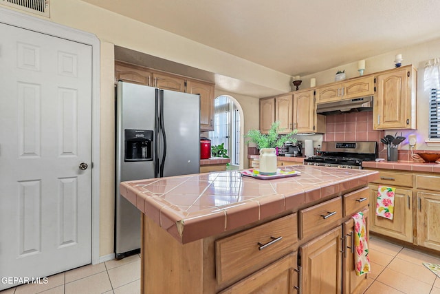 9769 Galilee Dr, El Paso, TX 79927 - kitchen featuring tile counters, under cabinet range hood, stainless steel appliances, light tile patterned floors, and light brown cabinets