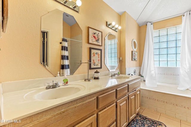 9769 Galilee Dr, El Paso, TX 79927 - bathroom featuring tile patterned flooring, a textured ceiling, double vanity, a textured wall, and a tub to relax in